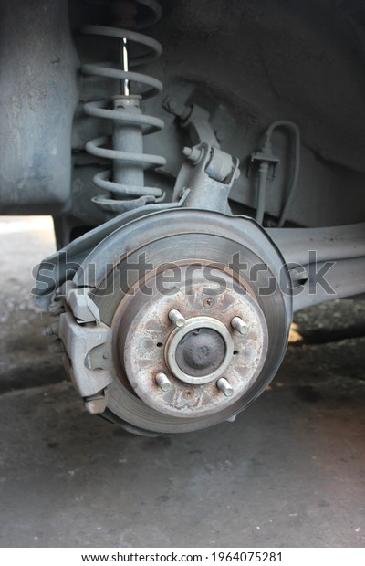 Closeup disc brake of the vehicle\
damaged, In process of new tire replacement. Car brake repairing in\
garage. Vertical image and Copy space for\
text.