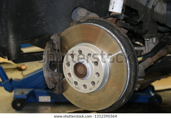 Closeup disc brake of the vehicle for repair.\
Detail image of car\
brakes.
