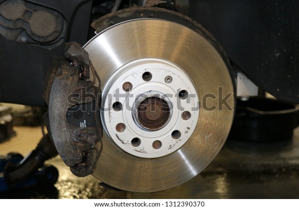 Closeup disc brake of the vehicle for repair.\
Detail image of car\
brakes.