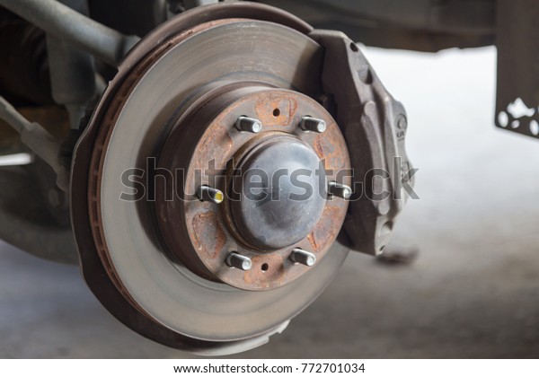 Closeup disc
brake of the vehicle for repair, in process of new tire
replacement. Car brake repairing in
garage