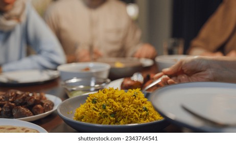 Close-up dish of halal food biryani rice on plate. Asia muslim sweet daughter serve food to mother Ramadan dinner together at home. Family celebration end of Eid al-Fitr togetherness at home. - Powered by Shutterstock