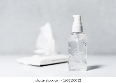 Close-up Of Dispenser Bottle With Sanitizer Antibacterial Gel, And Wipes Wet On White Table, Coronavirus Prevention.