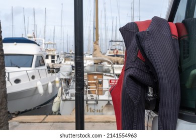 Close-up Of A Diving Wetsuit Hanging On The Rear-view Mirror Of A Van At The S'Arenal Yacht Club, Mallorca Island, Spain