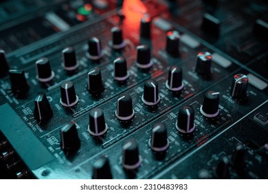 Closeup of DJ equipment, mixer or turntable in neon light, copy space - Shutterstock ID 2310483983