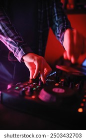 A close-up of the DJ's hands behind the console. 