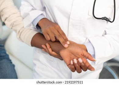 Close-up of doctor checking pulse. Woman doctor talking to female patient in hospital office while examining the pulse by hand. Healthcare and medical service concept