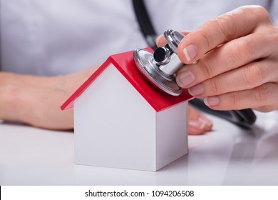 Close-up Of A Doctor Checking Simple Model House With Stethoscope - Powered by Shutterstock