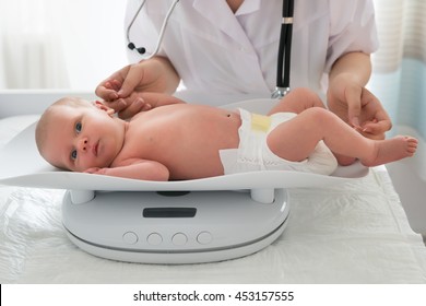 Close-up Of A Doctor Checking Weight Of Cute Little Baby