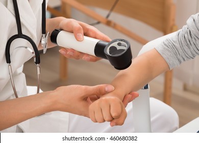 Close-up Of Doctor Examining Skin Of Child Patient With Dermatoscope - Powered by Shutterstock