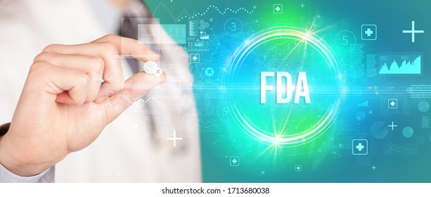 Close-up of a doctor giving you a pill with FDA abbreviation, virology concept
