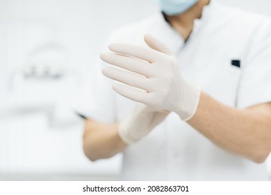 Closeup doctor hands in gloves. Rubber glove manufacturing, human hand is wearing latex gloves. Doctor putting on nitrile protective gloves