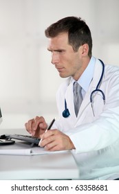 Closeup Of Doctor At His Desk In Front Of Computer