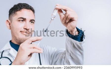 Closeup of doctor holding syringe and antidote isolated. Smiling doctor holding syringe with antidote on isolated background