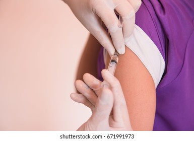 closeup of doctor injecting patient with syringe in the hospital . health care. - Shutterstock ID 671991973