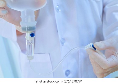 Closeup Doctor Or Nurse In White Uniform Hand Holding  Drip Iv And Infusion Pump For Treatment Patient In Sickroom Clinic Hospital With White Curtain 