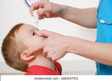 Closeup Of Doctor Pouring Eye Drops In Eye Her Patient. Studio Shot