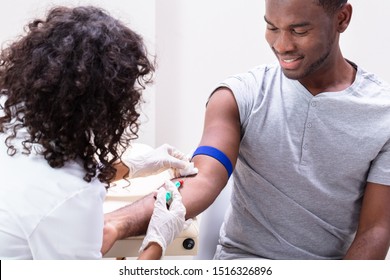 Close-up Of Doctor Taking Blood Sample From Patient's Arm