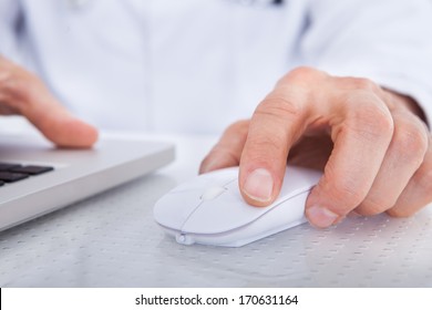 Close-up Of Doctor Using Laptop In Front Of Stethoscope At Desk