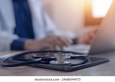 Close-up of doctor working on laptop computer with digital tablet on table in doctor's office medical and health care concept - Powered by Shutterstock