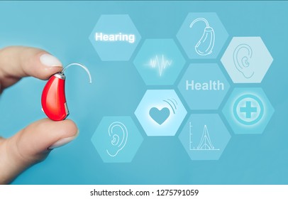 Close-up Of A Doctors Hand Holding Modern Hearing Aid With Hearing Icons Flow On Virtual Screen.concept Illustrates Future Technologies For The Treatment Deafness