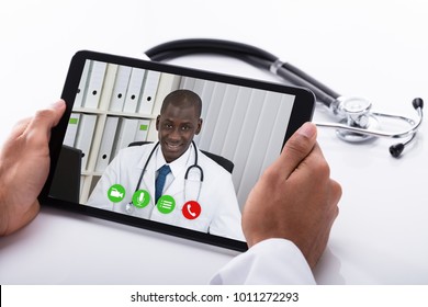 Close-up Of A Doctor's Hand Video Conferencing With African Male Colleague On Digital Tablet - Powered by Shutterstock