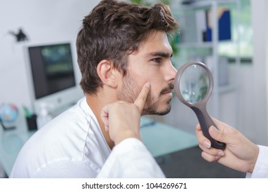 close-up of doctors hands checking mans moles