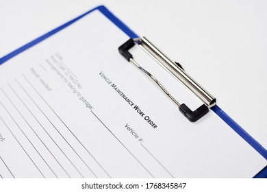 A Closeup Of A Document Entitled Vehicle Maintenance Work Order Form On A Blue Clipboard