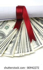 Close-up of dollars and a diploma with red ribbon