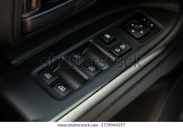 closeup\
of a door control panel in a new car. Arm rest with window control\
panel, door lock button, and mirror\
control.\
\

