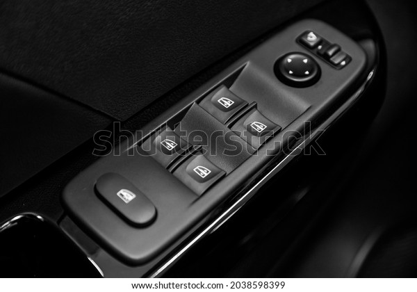 closeup of a\
door control panel in a new car. Arm rest with window control\
panel, door lock button, and mirror\
control.