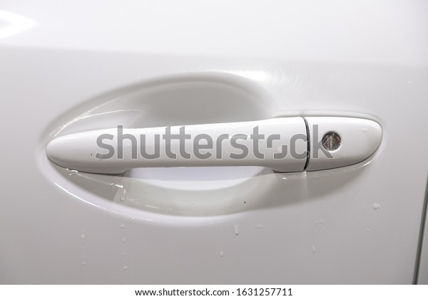 Close-up door handle of a\
white car