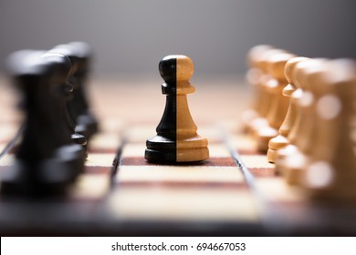 Closeup of double color pawn amidst other chess pieces on board game - Shutterstock ID 694667053