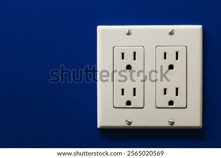 close-up of double receptacle electrical wall socket for North America for presentations or design projects isolated on a blue background 