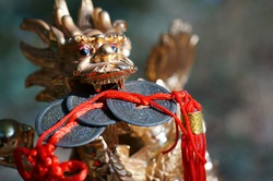 Close-up Dragon Figurine. In The Dragon's Teeth Is A Bunch Of Chinese Coins. Symbol Of Well-being And Monetary Prosperity.