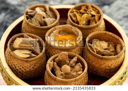 Closeup dreid herbs and herbal power in gold tray ingredients for Thai alternative medicine therapy.