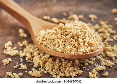 Closeup Of Dried Raw Soya Mince In Wooden Spoon