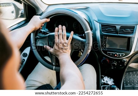 Close-up of driver honking car horn. Hand of angry driver honking car horn. Concept of impatient driver honking car horn, Driver man honking car horn 商業照片 © 