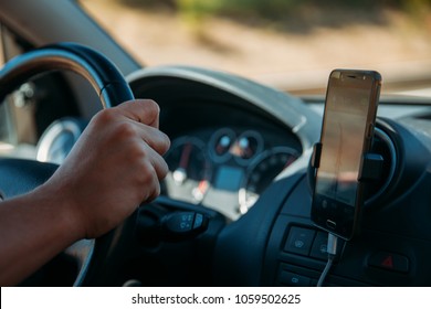 Closeup of driver using GPS from a smartphone while traveling.