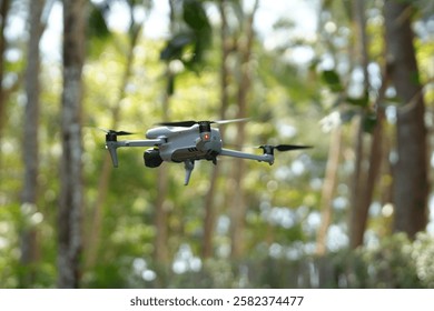 Close-up of drone quadcopter with digital camera flying in air. Equipment captures video footage. Outdoors activity with device