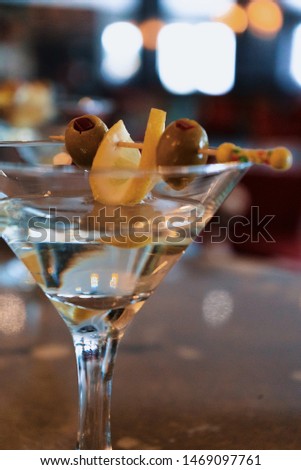 Close-up dry martini with green olives at a hotel bar