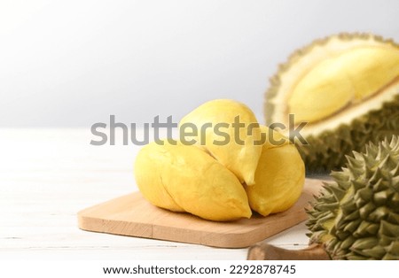 Close-up Durian pulp with cut in half on white wooden table.