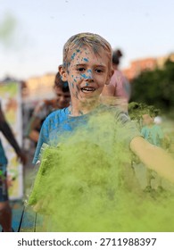 A close-up, dynamic portrait capturing a joyful child participating in a color festival Holi