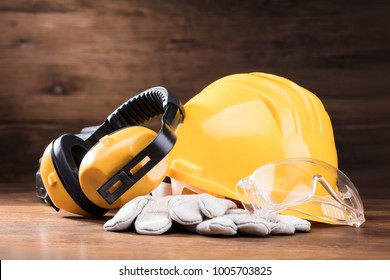 Close-up Of Ear Muff, Safety Glasses, And White Gloves On The Wooden Table - Powered by Shutterstock