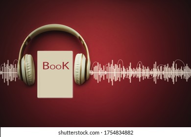 Close-up earphones and Audiobook on red background with Audio track. Audio, listen. Audiobook concept