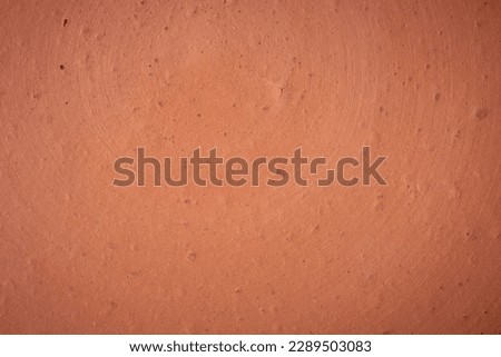close-up of earthenware surface, full frame background, red handmade clay pottery or terra cotta porous texture, soft focus with copy space