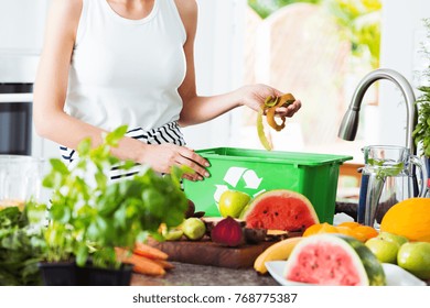 Close-up of eco friendly woman disposing of leftovers into compost bin while preparing salad - Powered by Shutterstock