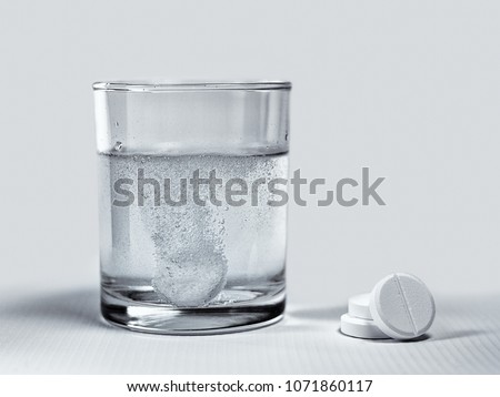 Closeup of effervescent tablets dissolving in a glass of water