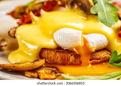 Close-up of eggs Benedict with hollandaise sauce and liquid yolk