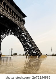 Close-up of the Eiffel Tower’s massive base pillar, highlighting its detailed iron latticework and grand architectural strength against the open sky.