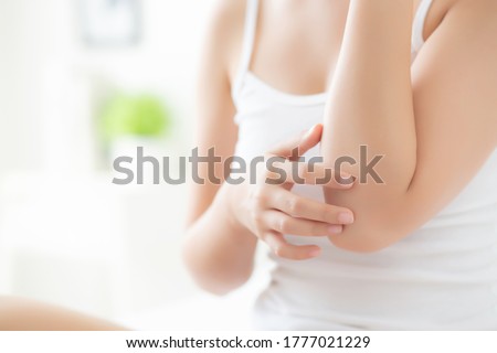 Closeup elbow of beautiful asian woman applying skincare and moisturizer cream or treatment for scratch and itchy, asia girl applying cream and lotion for dryness of skin care with cosmetic makeup.